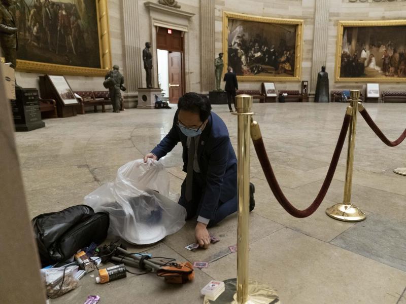 Rep. Andy Kim, D-N.J., cleans up debris and personal belongings strewn across the floor of the Rotunda in the early morning hours of Thursday, Jan. 7, 2021, after protesters stormed the Capitol in Washington, on Wednesday. (AP Photo/Andrew Harnik) Rep. Andy Kim, D-N.J., cleans up debris and personal belongings strewn across the floor of the Rotunda in the early morning hours of Thursday, Jan. 7, 2021, after protesters stormed the Capitol in Washington, on Wednesday. (AP Photo/Andrew Harnik)