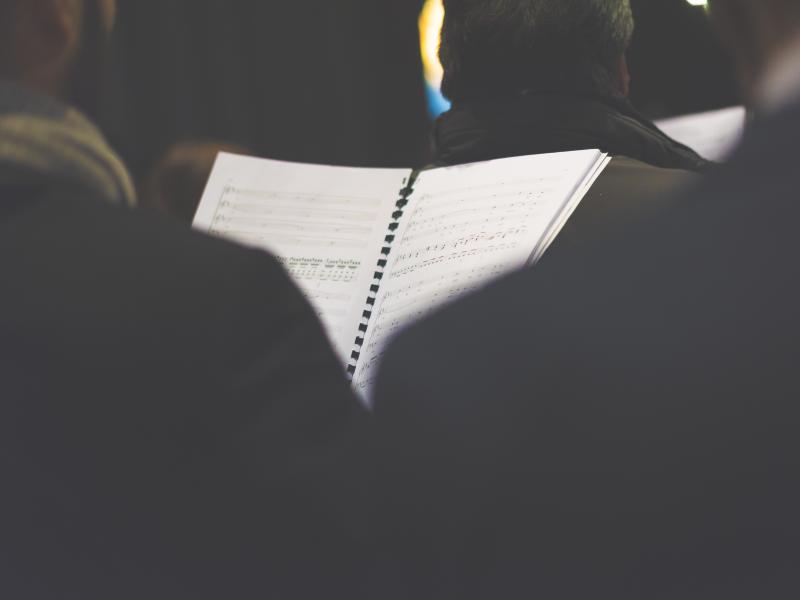 Classical music concert with a sheet music in the foreground Classical music concert with a sheet music in the foreground