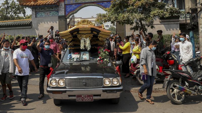 Bystanders flash a three-fingered sign of resistance as the body of Kyal Sin leaves the Yunnan Chinese temple in Mandalay, Myanmar earlier this week. Bystanders flash a three-fingered sign of resistance as the body of Kyal Sin leaves the Yunnan Chinese temple in Mandalay, Myanmar earlier this week.