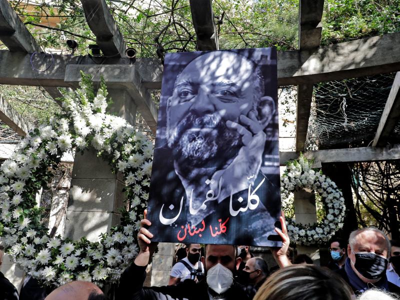 Friends and family members of slain prominent Lebanese activist and intellectual Lokman Slim (shown in the raised image), attend a memorial ceremony in the garden of the family residence in the capital Beirut's southern suburbs, a week after he was found Friends and family members of slain prominent Lebanese activist and intellectual Lokman Slim (shown in the raised image), attend a memorial ceremony in the garden of the family residence in the capital Beirut's southern suburbs, a week after he was found