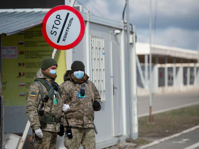 Ukrainian border guards wear protective face masks at a checkpoint with the territories controlled by Russia-backed separatists in the Donetsk region. Ukrainian border guards wear protective face masks at a checkpoint with the territories controlled by Russia-backed separatists in the Donetsk region.