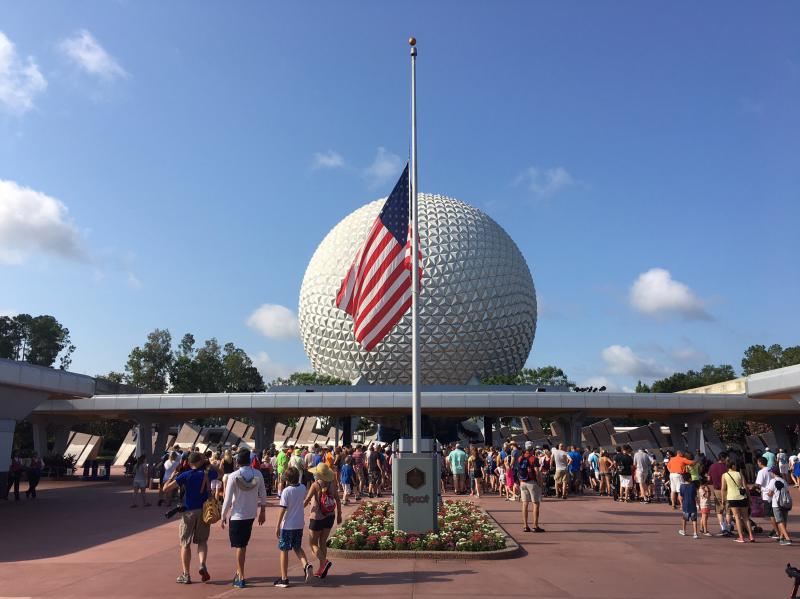 Tourists walk past the flag flying at half-staff at Disney's Epcot theme park in Orlando on Monday. Tourists walk past the flag flying at half-staff at Disney's Epcot theme park in Orlando on Monday.