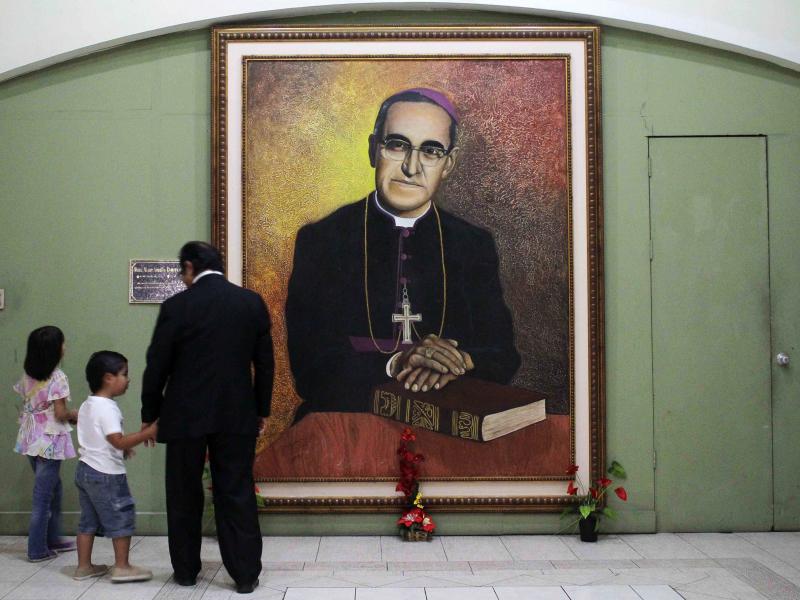 People look at a portrait of Oscar Romero at the cathedral of San Salvador, where as archbishop he resisted a brutal regime. He was murdered and the Vatican has declared him a martyr. People look at a portrait of Oscar Romero at the cathedral of San Salvador, where as archbishop he resisted a brutal regime. He was murdered and the Vatican has declared him a martyr.