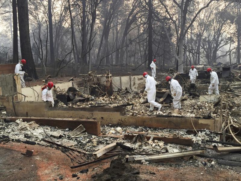 Volunteer rescue workers search for human remains in the rubble of homes burned in the Camp Fire in Paradise, Calif. State officials say the fire was caused by PG&E power lines. Volunteer rescue workers search for human remains in the rubble of homes burned in the Camp Fire in Paradise, Calif. State officials say the fire was caused by PG&E power lines.