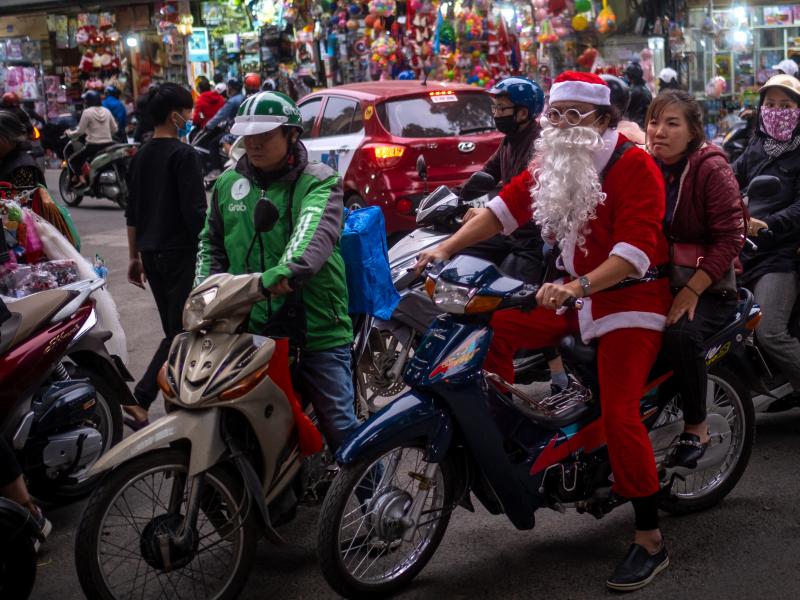 A man in a Santa Claus costume rides a motorbike in the Old Quarter on Dec. 24, 2020, in Hanoi, Vietnam. A man in a Santa Claus costume rides a motorbike in the Old Quarter on Dec. 24, 2020, in Hanoi, Vietnam.