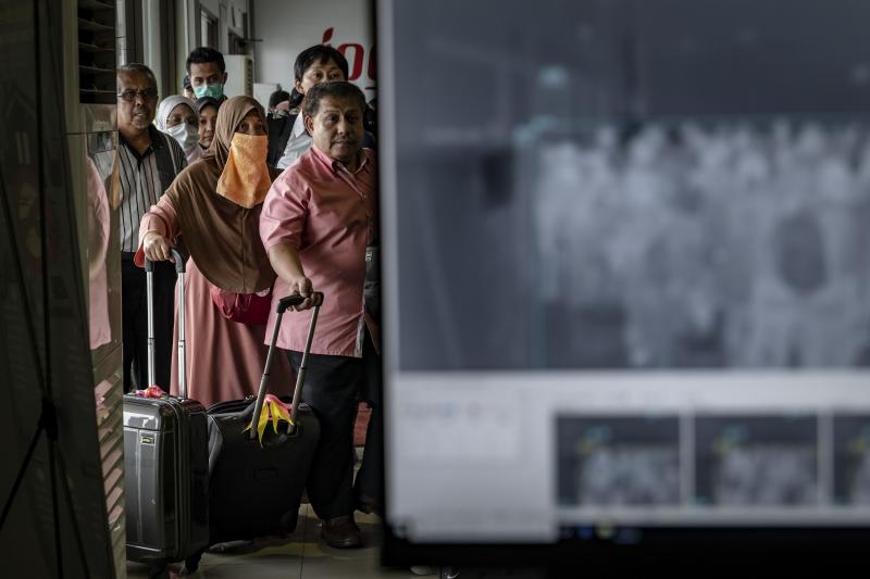 Passengers from an international flight have their temperature checked as they pass a thermal scanner monitor, seen at right, upon arrival at the international Airport in Yogyakarta, Indonesia on Thursday. Passengers from an international flight have their temperature checked as they pass a thermal scanner monitor, seen at right, upon arrival at the international Airport in Yogyakarta, Indonesia on Thursday.