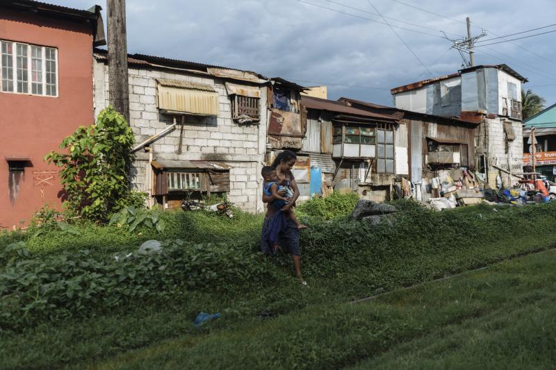 Ros Jane walks with her child by the railway near her home in Manila. She became pregnant at age 16. Ros Jane walks with her child by the railway near her home in Manila. She became pregnant at age 16.