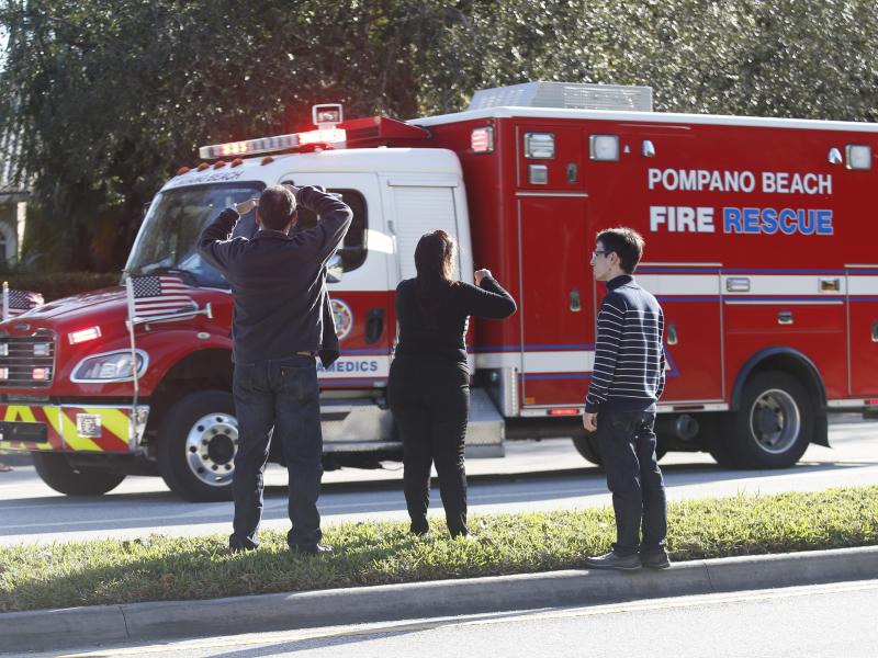 Family members watch a rescue vehicle pass by on Feb. 14 in Parkland, Fla. Family members watch a rescue vehicle pass by on Feb. 14 in Parkland, Fla.