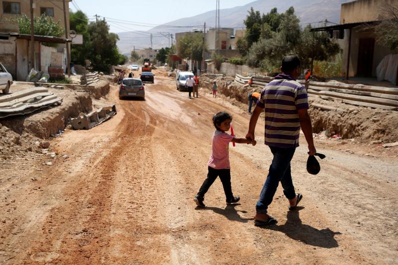 A father and his daughter cross a street under renovations as part of a U.S. aid grant in the village of al-Badhan, north of Nablus in Israeli occupied West Bank in August 2018. A father and his daughter cross a street under renovations as part of a U.S. aid grant in the village of al-Badhan, north of Nablus in Israeli occupied West Bank in August 2018.