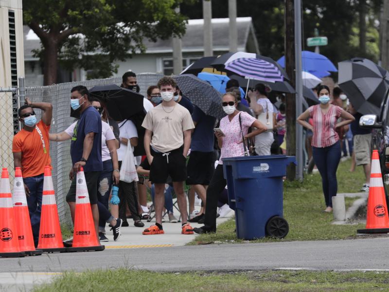 People wait in line outside a testing site in Florida. The state has seen unprecedented surges in coronavirus cases in recent weeks. People wait in line outside a testing site in Florida. The state has seen unprecedented surges in coronavirus cases in recent weeks.