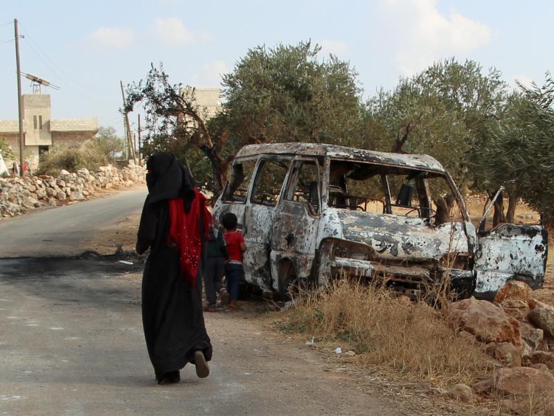 A woman walks past a wrecked van near the northwestern Syrian village of Barisha. Local residents and medical staff told NPR that noncombatant civilians who were in the van were injured and killed last year the night of the U.S. raid on the compound of IS A woman walks past a wrecked van near the northwestern Syrian village of Barisha. Local residents and medical staff told NPR that noncombatant civilians who were in the van were injured and killed last year the night of the U.S. raid on the compound of IS