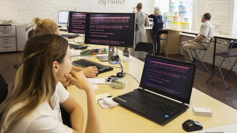 Employees at a store in Kiev, Ukraine, read a ransomware demand for $300 in bitcoin to free files encrypted by the Petya software virus. The malicious program has spread to dozens of countries. Employees at a store in Kiev, Ukraine, read a ransomware demand for $300 in bitcoin to free files encrypted by the Petya software virus. The malicious program has spread to dozens of countries.