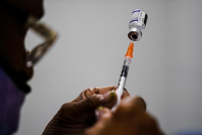 A syringe is prepared with the Pfizer COVID-19 vaccine at a vaccination clinic in Chester, Pa., on Dec. 15, 2021. Pfizer says tweaking its COVID-19 vaccine to better target the omicron variant is safe and boosts protection. A syringe is prepared with the Pfizer COVID-19 vaccine at a vaccination clinic in Chester, Pa., on Dec. 15, 2021. Pfizer says tweaking its COVID-19 vaccine to better target the omicron variant is safe and boosts protection.