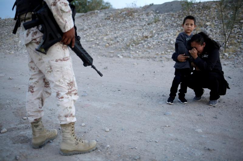 Guatemalan migrant Lety Pérez embraces her son, Anthony, while pleading with a Mexican National Guard member to let them cross into the United States, near Juárez, Mexico, on Monday. Guatemalan migrant Lety Pérez embraces her son, Anthony, while pleading with a Mexican National Guard member to let them cross into the United States, near Juárez, Mexico, on Monday.