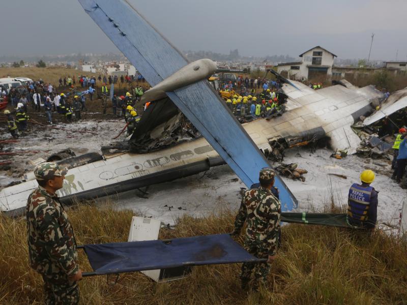 Nepalese rescuers work after a passenger plane from Bangladesh crashed at the airport in Kathmandu, Nepal, on Monday. Nepalese rescuers work after a passenger plane from Bangladesh crashed at the airport in Kathmandu, Nepal, on Monday.