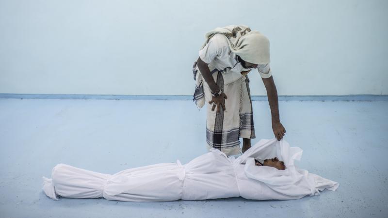 A friend attends to the body of a Yemeni fighter on Sept. 22. A friend attends to the body of a Yemeni fighter on Sept. 22.