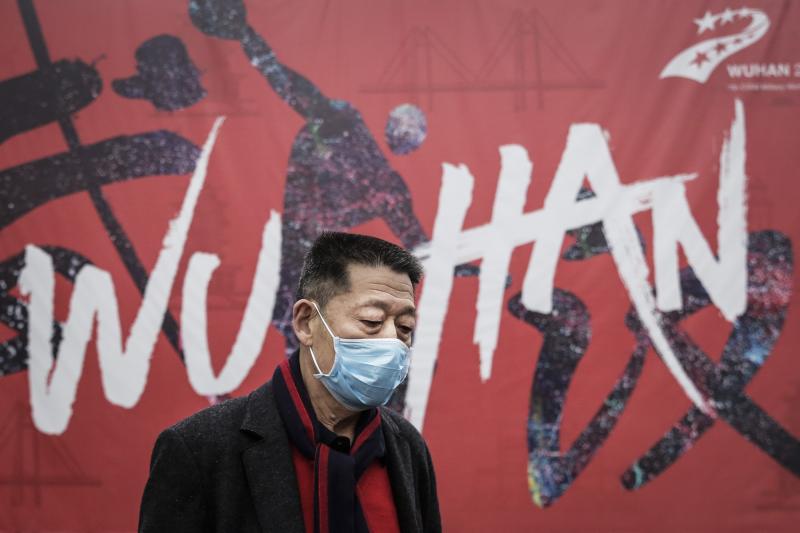 A man in Wuhan, China, the epicenter of the current coronavirus outbreak, walks by a local mural. A man in Wuhan, China, the epicenter of the current coronavirus outbreak, walks by a local mural.