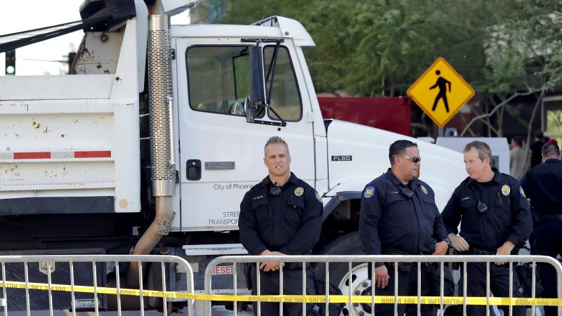 Phoenix police officers stand beside a dump truck blocking a road outside the Phoenix Convention Center on Aug. 22. Protests were held against President Trump as he planned to host a rally inside the convention center. Phoenix police officers stand beside a dump truck blocking a road outside the Phoenix Convention Center on Aug. 22. Protests were held against President Trump as he planned to host a rally inside the convention center.