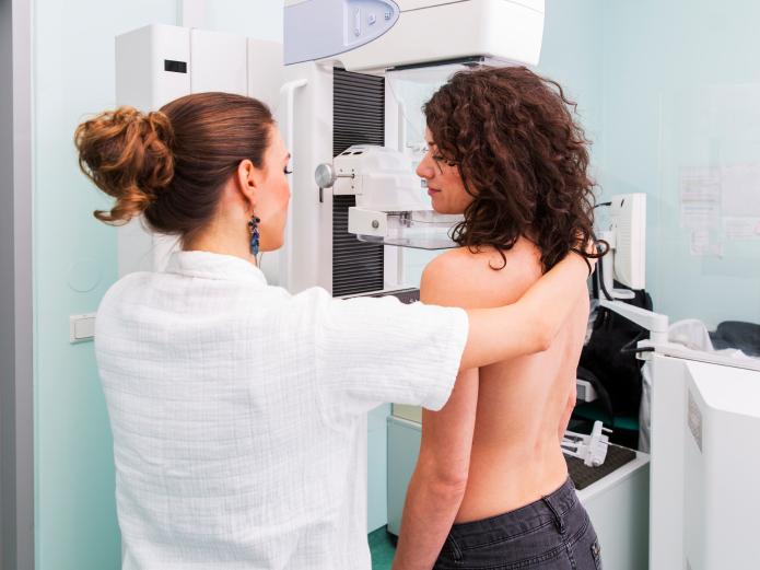 Doctor gives a young women a mammogram. Doctor gives a young women a mammogram.