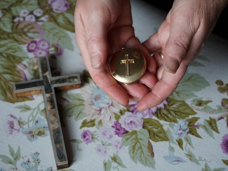 Marie Andrews holds a pyx, the vessel she uses to transport the consecrated Communion wafer to homebound parishioners. Andrews is an officially sanctioned Eucharistic minister in the Roman Catholic Church. Marie Andrews holds a pyx, the vessel she uses to transport the consecrated Communion wafer to homebound parishioners. Andrews is an officially sanctioned Eucharistic minister in the Roman Catholic Church.