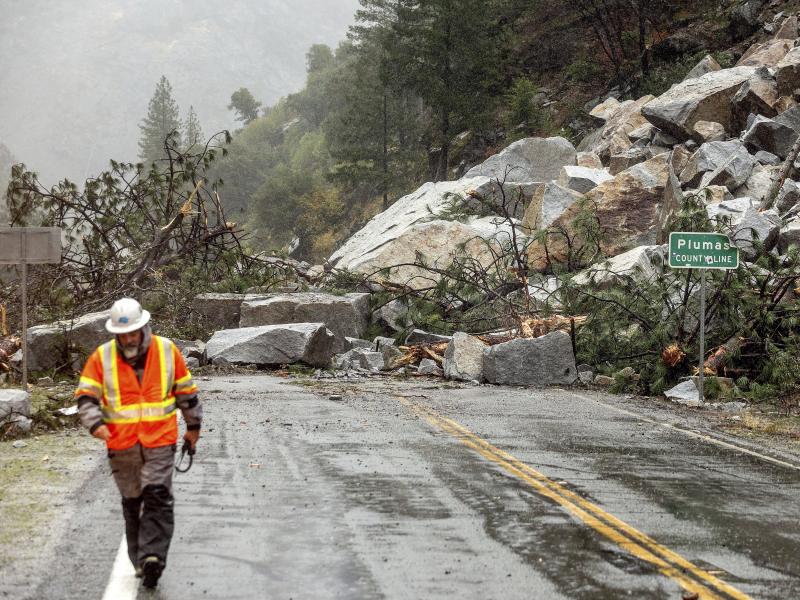 Caltrans maintenance supervisor Matt Martin walks by a landslide covering Highway 70 in the Dixie Fire zone on Sunday in Plumas County, Calif. Heavy rains blanketing Northern California created slide and flood hazards in land scorched during last summer's Caltrans maintenance supervisor Matt Martin walks by a landslide covering Highway 70 in the Dixie Fire zone on Sunday in Plumas County, Calif. Heavy rains blanketing Northern California created slide and flood hazards in land scorched during last summer's