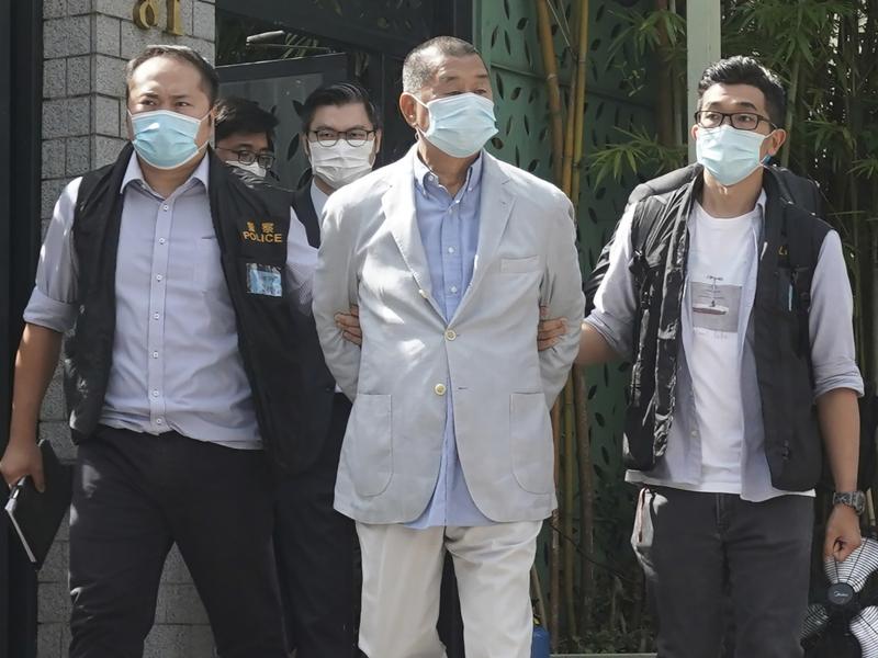 Hong Kong media tycoon Jimmy Lai (center) is arrested at his home in Hong Kong on Monday. Hong Kong police raided the publisher's headquarters in the highest-profile use yet of the new national security law Beijing imposed on the city after protests last Hong Kong media tycoon Jimmy Lai (center) is arrested at his home in Hong Kong on Monday. Hong Kong police raided the publisher's headquarters in the highest-profile use yet of the new national security law Beijing imposed on the city after protests last