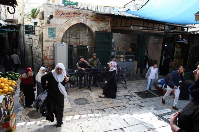 Palestinian shoppers walk near Damascus Gate in Jerusalem's Old City, under the watchful eye of Israeli police and wall-mounted security cameras. Amid the recent violence, there's talk of placing cameras inside the city's most contested religious site, kn Palestinian shoppers walk near Damascus Gate in Jerusalem's Old City, under the watchful eye of Israeli police and wall-mounted security cameras. Amid the recent violence, there's talk of placing cameras inside the city's most contested religious site, kn
