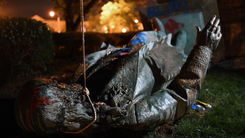 A statue commemorating Confederate Gen. Albert Pike sits on the ground moments after protesters toppled it late Friday night in Washington, D.C. A statue commemorating Confederate Gen. Albert Pike sits on the ground moments after protesters toppled it late Friday night in Washington, D.C.
