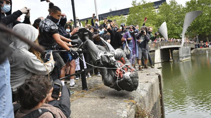 Protesters throw a statue of slave trader Edward Colston into Bristol Harbor on Sunday during a Black Lives Matter protest in England. Protesters throw a statue of slave trader Edward Colston into Bristol Harbor on Sunday during a Black Lives Matter protest in England.