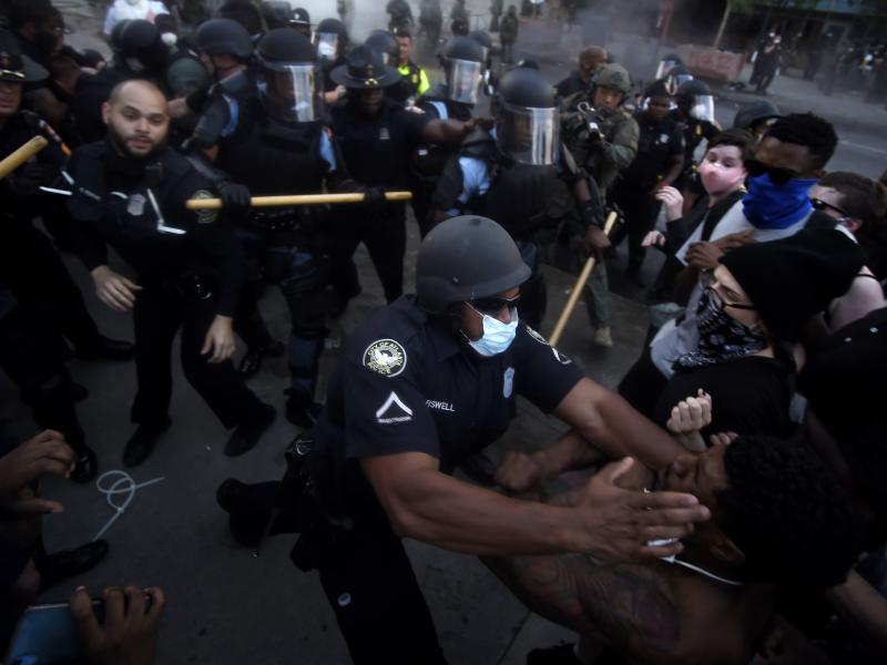Police officers and protesters clash on Friday near CNN Center in Atlanta, in response to George Floyd's death in police custody in Minneapolis on Memorial Day. Police officers and protesters clash on Friday near CNN Center in Atlanta, in response to George Floyd's death in police custody in Minneapolis on Memorial Day.