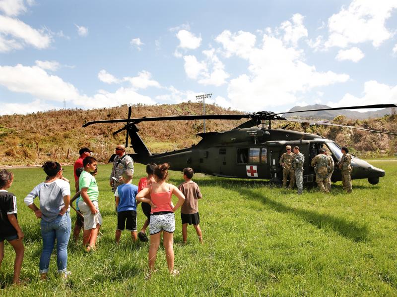 In the mountain town of Juyaya, Puerto Rico, last October, children watched as U.S. Army helicopters brought a team of physicians to assess the medical needs of the local hospital and residents. Going forward, health economists say, the U.S. territory wil In the mountain town of Juyaya, Puerto Rico, last October, children watched as U.S. Army helicopters brought a team of physicians to assess the medical needs of the local hospital and residents. Going forward, health economists say, the U.S. territory wil