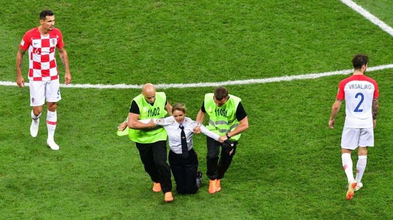 An intruder, identified as a member of the Russian collective and punk band Pussy Riot, is carried off the pitch during the 2018 World Cup final game between France and Croatia on Sunday. An intruder, identified as a member of the Russian collective and punk band Pussy Riot, is carried off the pitch during the 2018 World Cup final game between France and Croatia on Sunday.