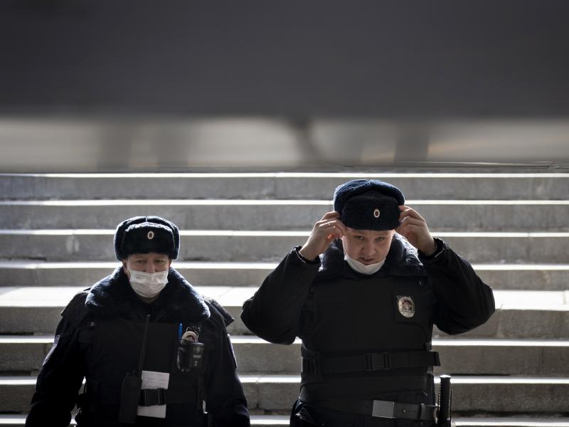 Russian police officers, wearing face masks to guard against the coronavirus, descend into a pedestrian underpass as they patrol to enforce a self-isolation regime in Moscow. Russian police officers, wearing face masks to guard against the coronavirus, descend into a pedestrian underpass as they patrol to enforce a self-isolation regime in Moscow.