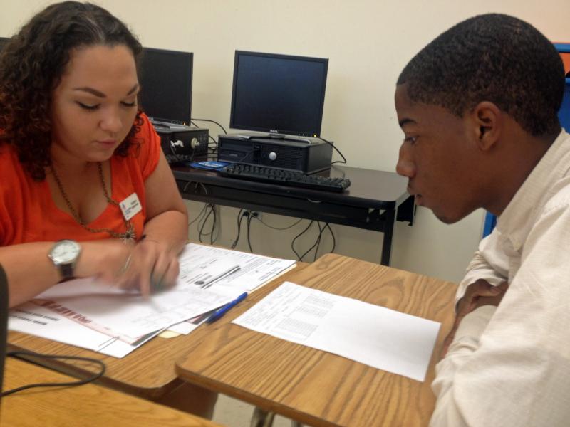 Student Mack Godbee and mentor Natasha Santana-Viera go over Godbee's report card. Godbee's performance has improved since a data monitoring program identified him as a dropout risk. Student Mack Godbee and mentor Natasha Santana-Viera go over Godbee's report card. Godbee's performance has improved since a data monitoring program identified him as a dropout risk.
