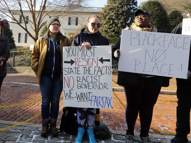 Demonstrators hold signs and chant in Richmond, Va., on Feb. 2. They were calling for the resignation of Gov. Ralph Northam after a racist photo on his medical school yearbook page came to light. He denies that he is in the photo but admits to once dressi Demonstrators hold signs and chant in Richmond, Va., on Feb. 2. They were calling for the resignation of Gov. Ralph Northam after a racist photo on his medical school yearbook page came to light. He denies that he is in the photo but admits to once dressi