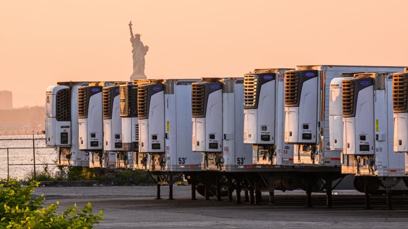 The Statue of Liberty is visible behind refrigeration trucks that function as temporary morgues at New York City's South Brooklyn Marine Terminal. "If you're driving by ... you might just assume that this was some sort of distribution hub," Time reporter The Statue of Liberty is visible behind refrigeration trucks that function as temporary morgues at New York City's South Brooklyn Marine Terminal. "If you're driving by ... you might just assume that this was some sort of distribution hub," Time reporter