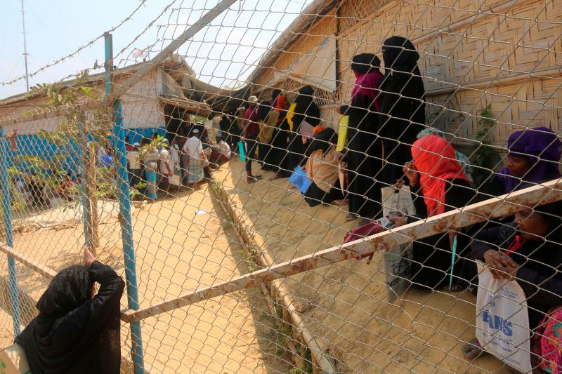 Rohingya refugees wait at a relief distribution point in the Kutupalong refugee camp in Bangladesh on March 24. Rohingya refugees wait at a relief distribution point in the Kutupalong refugee camp in Bangladesh on March 24.