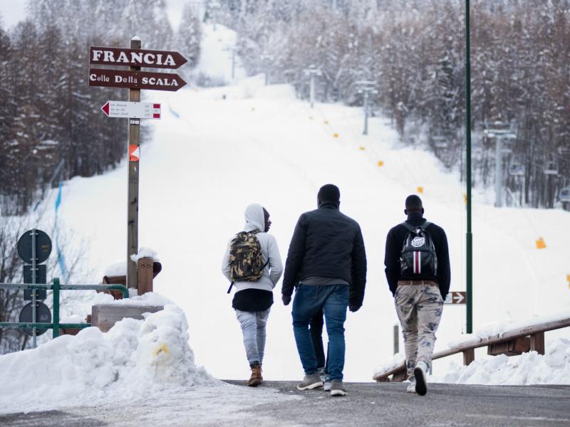 Migrants walk toward a snow-covered pass to cross the border from Italy to France, in January 2018 near Bardonecchia, Italian Alps. Migrants walk toward a snow-covered pass to cross the border from Italy to France, in January 2018 near Bardonecchia, Italian Alps.