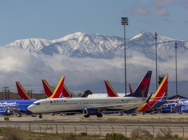 A Delta Air Lines jet taxis past Southwest Airlines jets to be parked with a growing number of jets at Southern California Logistics Airport on Tuesday in Victorville, Calif. Airlines around the world are scrambling to find places to park planes. A Delta Air Lines jet taxis past Southwest Airlines jets to be parked with a growing number of jets at Southern California Logistics Airport on Tuesday in Victorville, Calif. Airlines around the world are scrambling to find places to park planes.