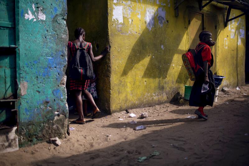 A girl wearing the More Than Me uniform walks into an alley in the West Point neighborhood of Monrovia, Liberia. A girl wearing the More Than Me uniform walks into an alley in the West Point neighborhood of Monrovia, Liberia.