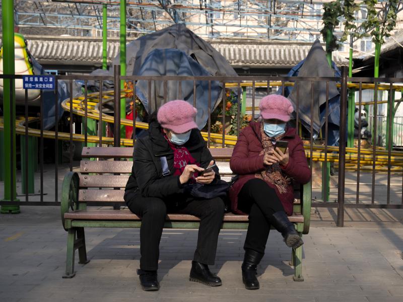 Women wearing face masks to protect against COVID-19 look at their smartphones at a public park in Beijing Wednesday. China is reporting a major drop in local COVID-19 infections in the northern city of Xi'an, which has been under a tight lockdown for the Women wearing face masks to protect against COVID-19 look at their smartphones at a public park in Beijing Wednesday. China is reporting a major drop in local COVID-19 infections in the northern city of Xi'an, which has been under a tight lockdown for the