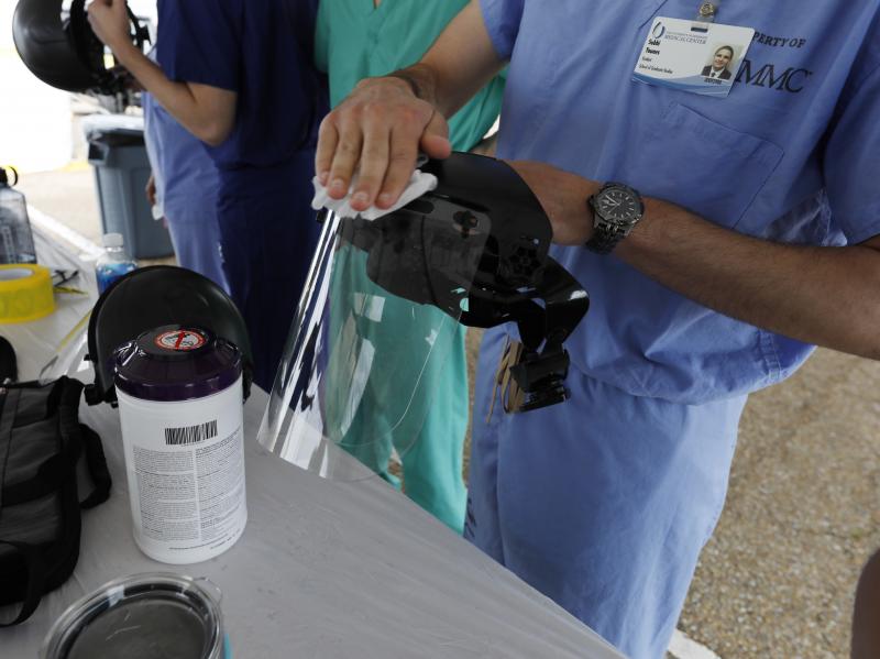 Medical professionals sanitize their facemasks prior to storing them away on March 23, 2020. They were preparing to collect specimens for coronavirus testing at the Mississippi State Fairgrounds in Jackson, Miss. Medical professionals sanitize their facemasks prior to storing them away on March 23, 2020. They were preparing to collect specimens for coronavirus testing at the Mississippi State Fairgrounds in Jackson, Miss.