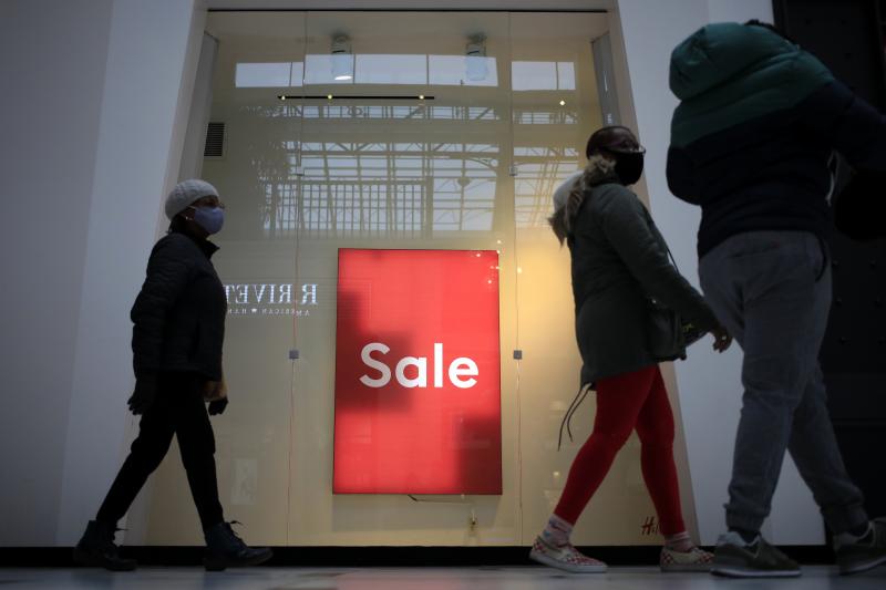 Shoppers walk past a "Sale" sign outside a store at the Easton Town Center Mall in Columbus, Ohio, on Jan. 7. Shoppers walk past a "Sale" sign outside a store at the Easton Town Center Mall in Columbus, Ohio, on Jan. 7.