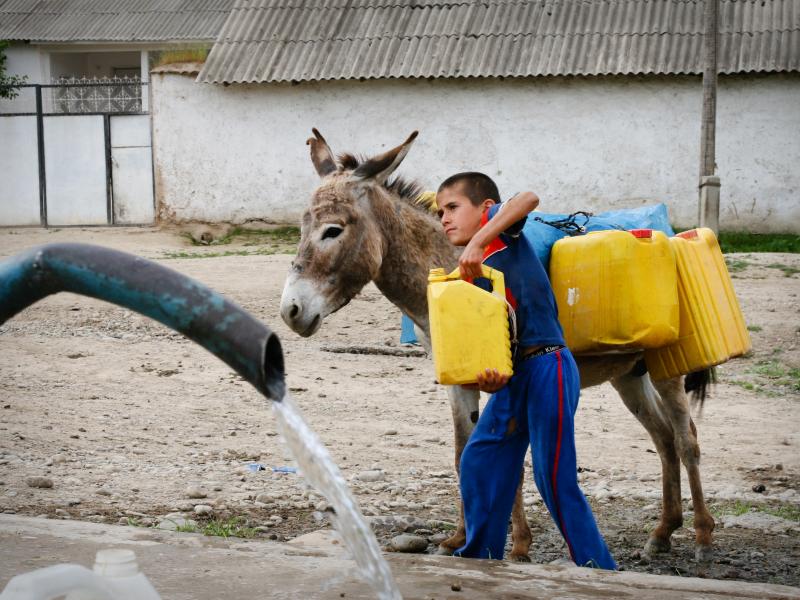 A boy collects water at a new spigot in Shululu, Tajikistan. Before the government built a new water system, villagers were allocated half-hour time slots to collect water from a trickling tap. A boy collects water at a new spigot in Shululu, Tajikistan. Before the government built a new water system, villagers were allocated half-hour time slots to collect water from a trickling tap.