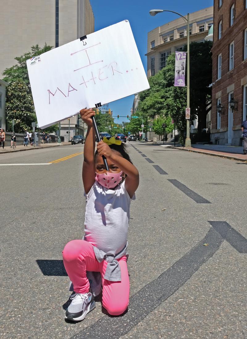 Nasiah Morris, 4, of Richmond, carries a sign during a march from Brown's Island to the 17th Street Market in Shockoe Bottom, June 7. The youngster, kneeling at 9th and Grace streets across from the State Capitol, attended the rally with her mother, Toya Nasiah Morris, 4, of Richmond, carries a sign during a march from Brown's Island to the 17th Street Market in Shockoe Bottom, June 7. The youngster, kneeling at 9th and Grace streets across from the State Capitol, attended the rally with her mother, Toya
