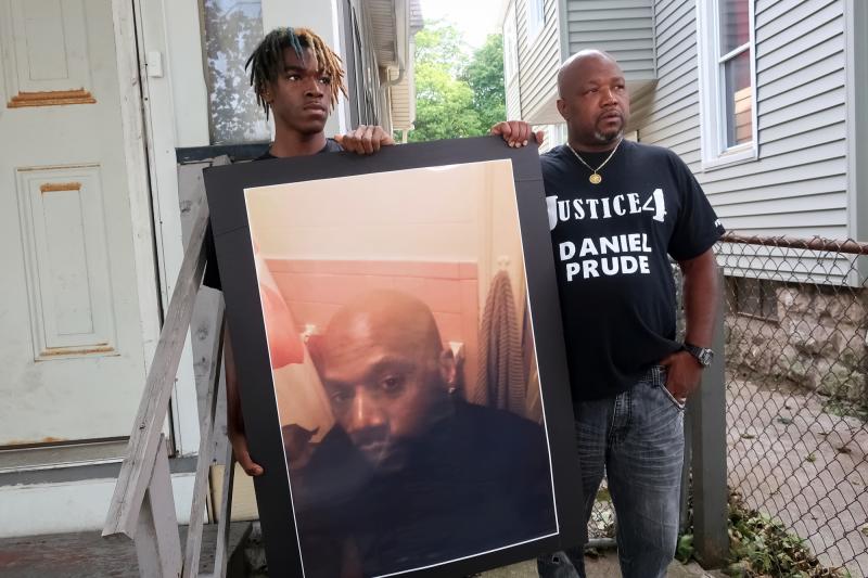 Family members Armin Prude (left) and Joe Prude stand with a picture of Daniel Prude in Rochester, N.Y., Thursday, Sept. 3, 2020. While suffering a mental health crisis, Prude, 41, suffocated after police in Rochester put a "spit hood" over his head while Family members Armin Prude (left) and Joe Prude stand with a picture of Daniel Prude in Rochester, N.Y., Thursday, Sept. 3, 2020. While suffering a mental health crisis, Prude, 41, suffocated after police in Rochester put a "spit hood" over his head while