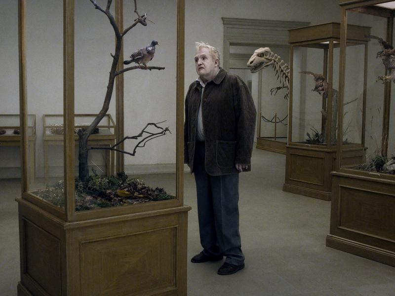 Andersson's new film, A Pigeon Sat on a Branch Reflecting on Existence, consists of a series of absurdist episodes. It opens with a man (Per Bergqvist) wandering a museum, looking at exhibits of stuffed birds. Andersson's new film, A Pigeon Sat on a Branch Reflecting on Existence, consists of a series of absurdist episodes. It opens with a man (Per Bergqvist) wandering a museum, looking at exhibits of stuffed birds.