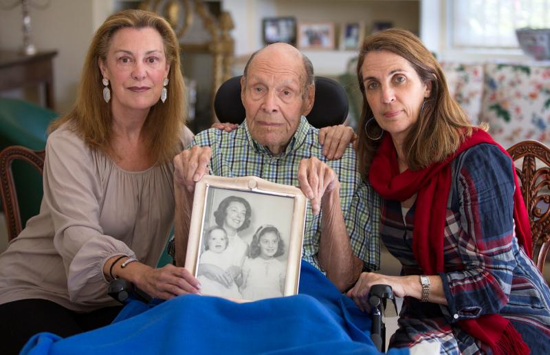 Laura Rees (left) and her sister Nancy Fee sit with their father, Joseph Fee, while holding a photo of his late wife, Elizabeth. Laura Rees (left) and her sister Nancy Fee sit with their father, Joseph Fee, while holding a photo of his late wife, Elizabeth.