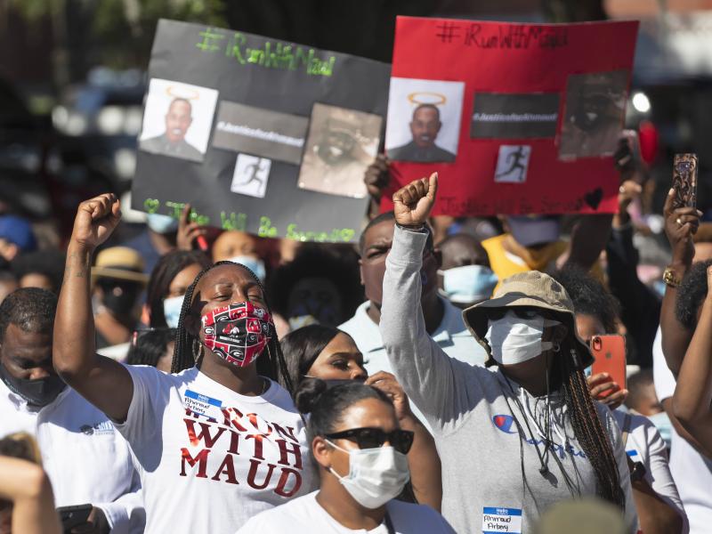 People react during a rally to protest the shooting of Ahmaud Arbery in Brunswick, Ga. People react during a rally to protest the shooting of Ahmaud Arbery in Brunswick, Ga.