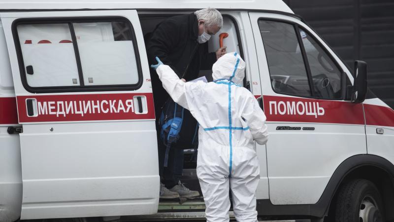 A medical worker helps a man suspected of infection with the coronavirus out of an ambulance at a hospital in Kommunarka, outside Moscow. A medical worker helps a man suspected of infection with the coronavirus out of an ambulance at a hospital in Kommunarka, outside Moscow.
